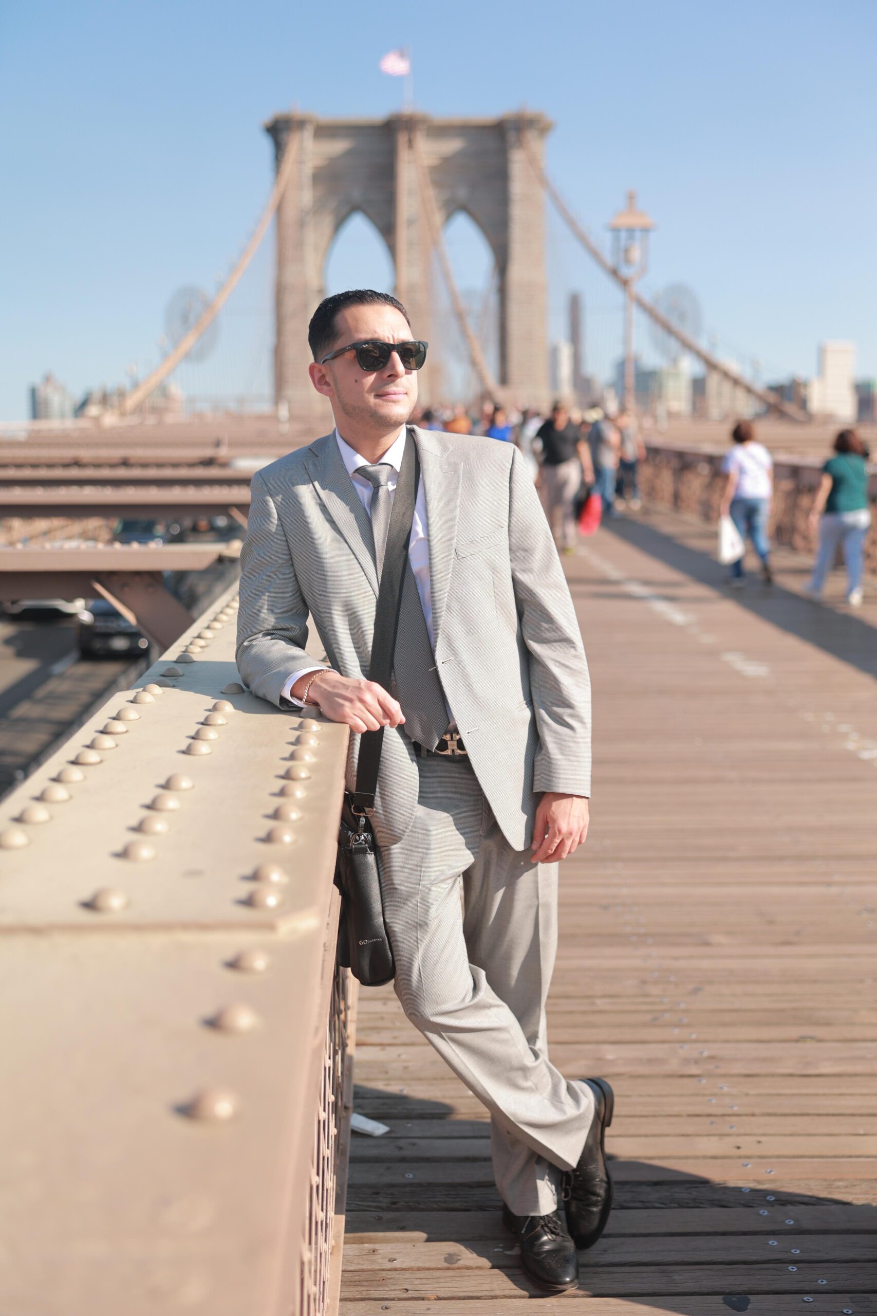 Migir Ilganayev standing on the Brooklyn Bridge walkway, Lower Manhattan behind him.
