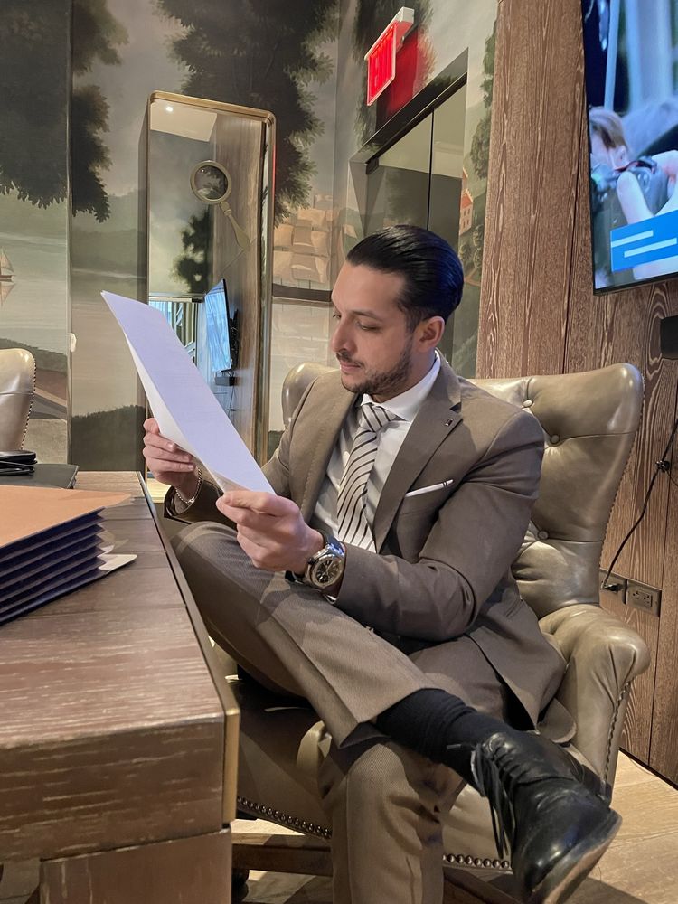 Migir Ilganayev seated in an armchair, reading a document.